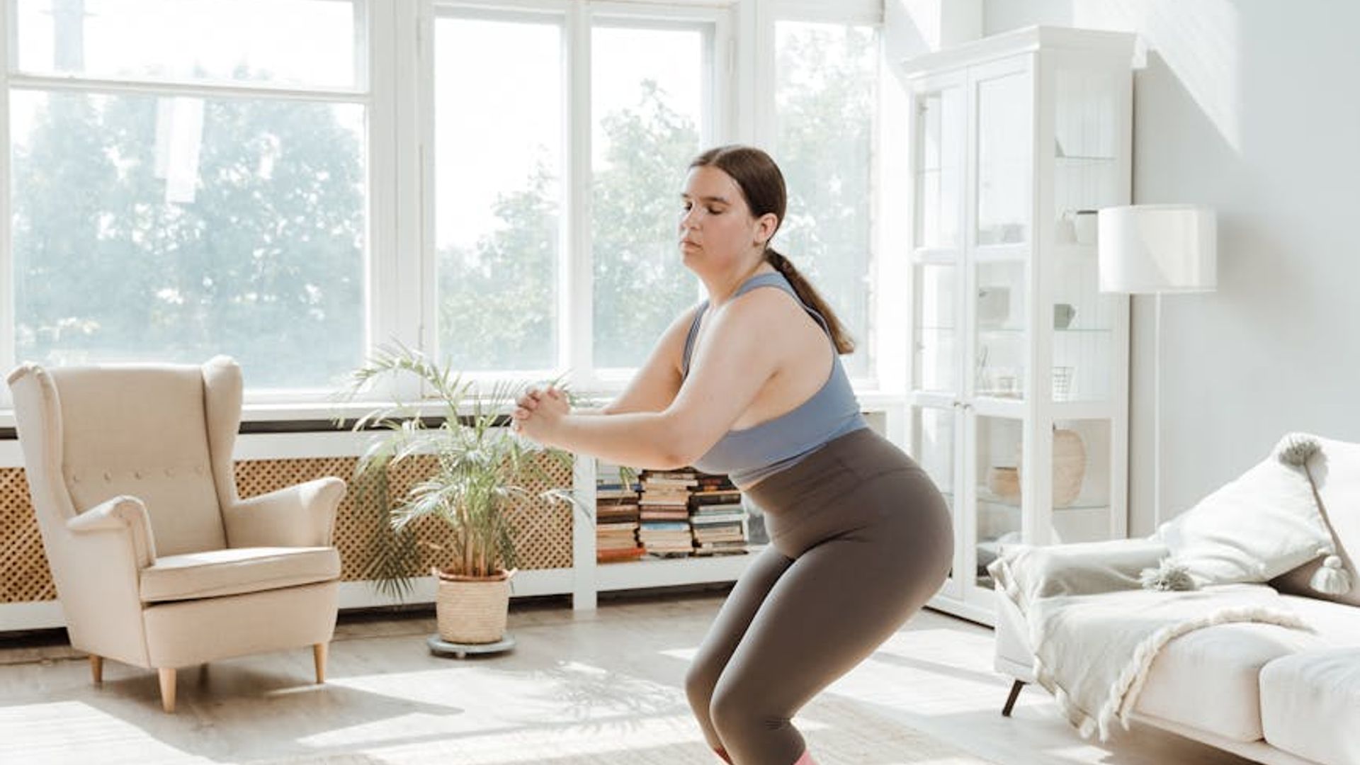 Athletic person doing energetic morning exercises in a bright room.